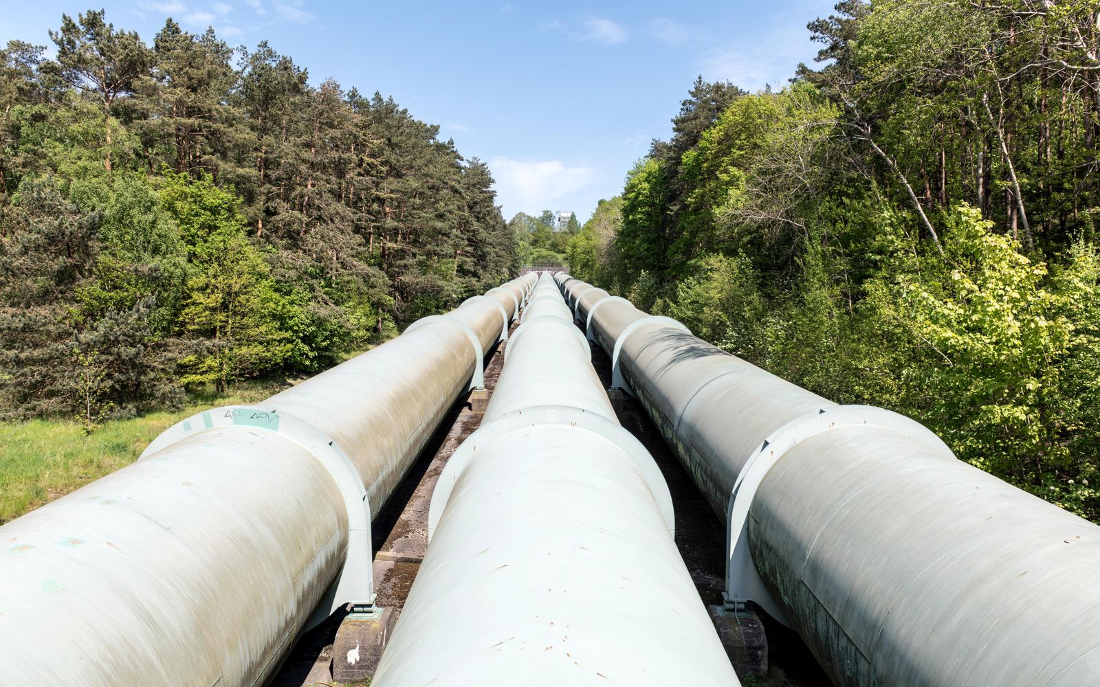 Parallel steel pipelines converging toward the horizon